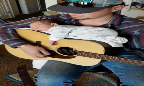 Bebeğini Gitarının Üzerinde Uyutan Baba