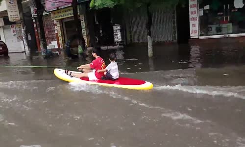 Motosiklet Arkasında Sel Sörfü Yapan Çocuklar